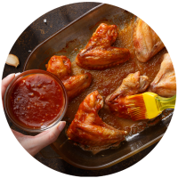 Brushing sauce on chicken wings